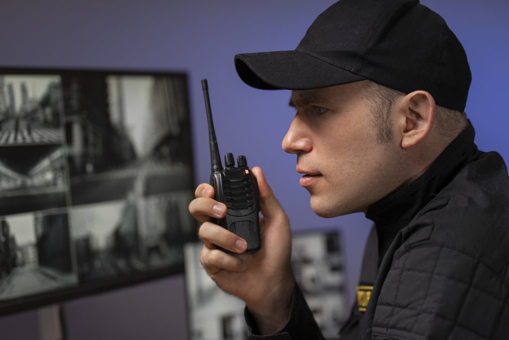 portrait male security guard with radio station camera screens